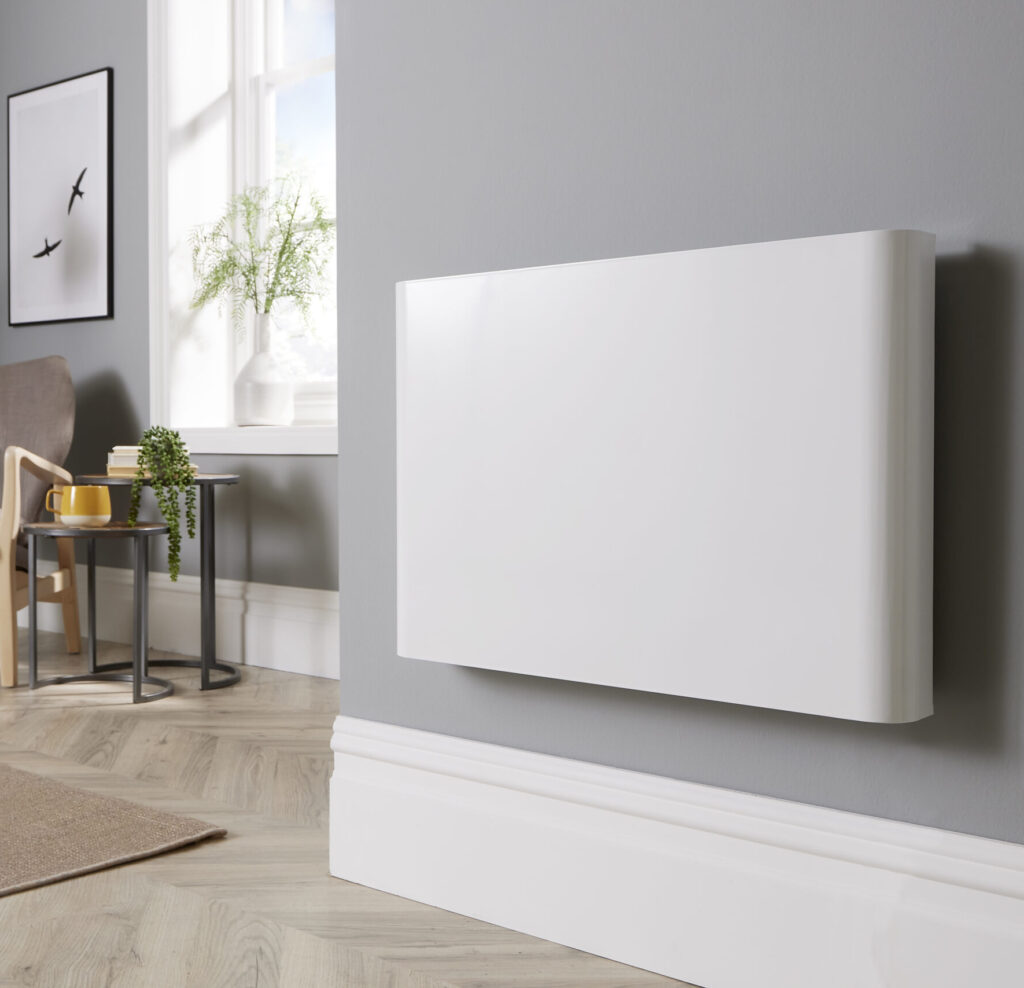 Main product image of the Ecopanel XT Electric Radiator set in a modern lounge decor and wall-mounted. The radiator is slimline, very high-quality and equipped with several energy-saving functions.